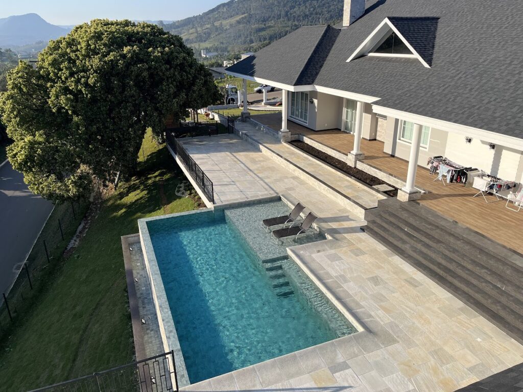 Piscina elevada com solário em deck e vista para o vale