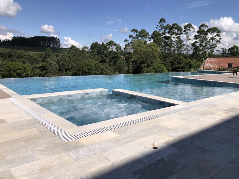 Piscina com borda infinita e spa projetada pela Ramiro Piscinas
