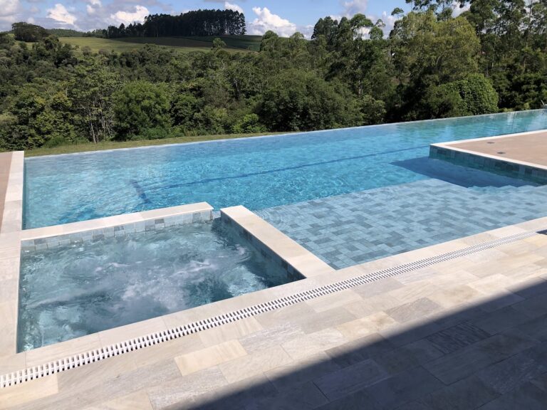 Piscina de alvenaria com borda infinita e revestimento em pastilha, projeto da Ramiro Piscinas no Alto Vale do Itajaí