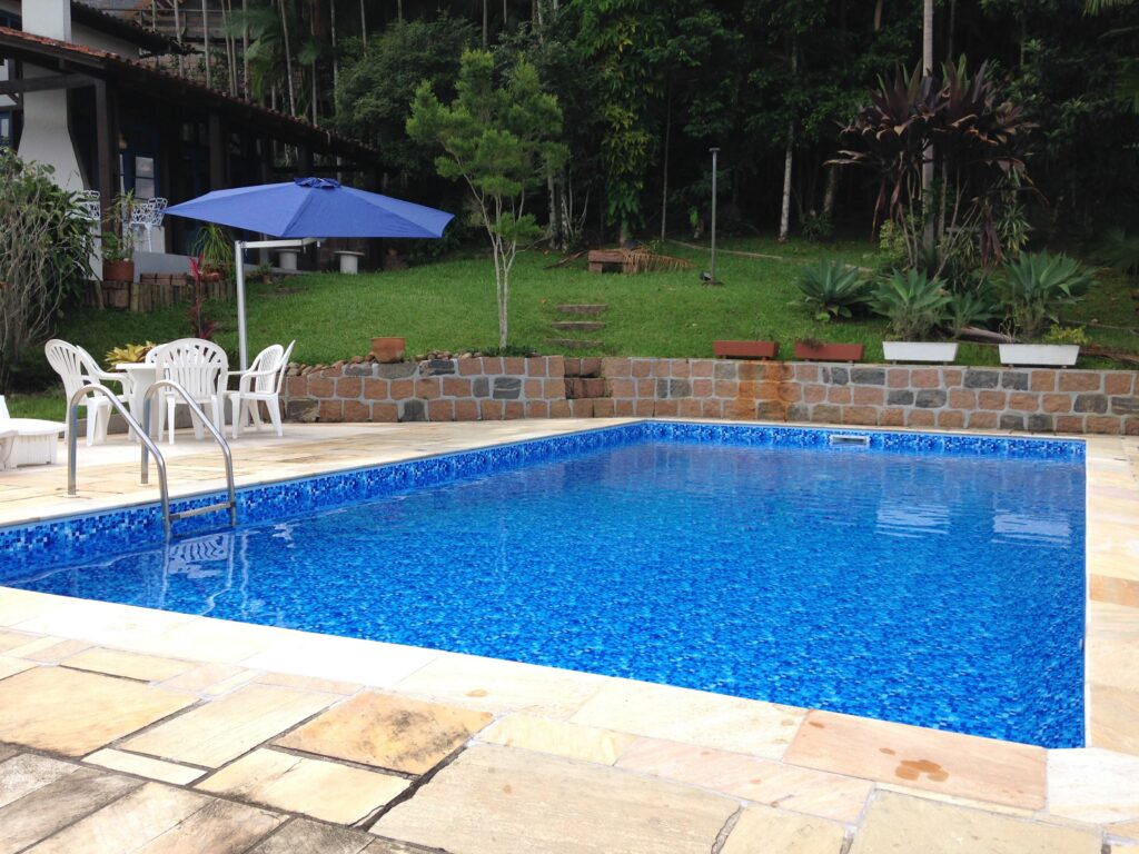 Piscina de vinil com escada em degraus e área verde ao redor
