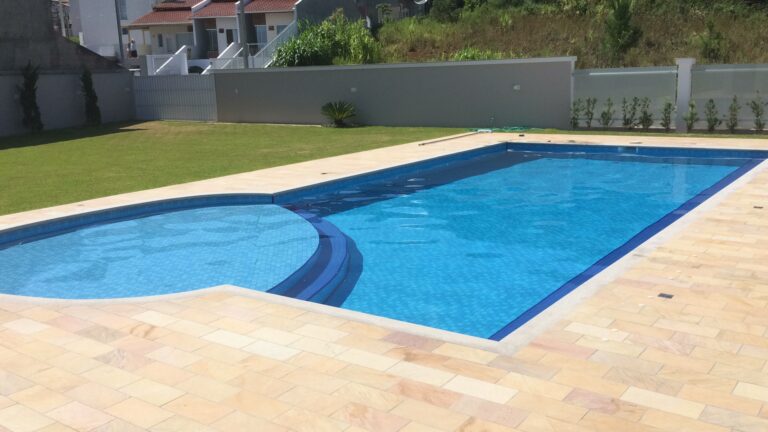 Piscina revestida em manta vinílica com área de lazer, projeto da Ramiro Piscinas
