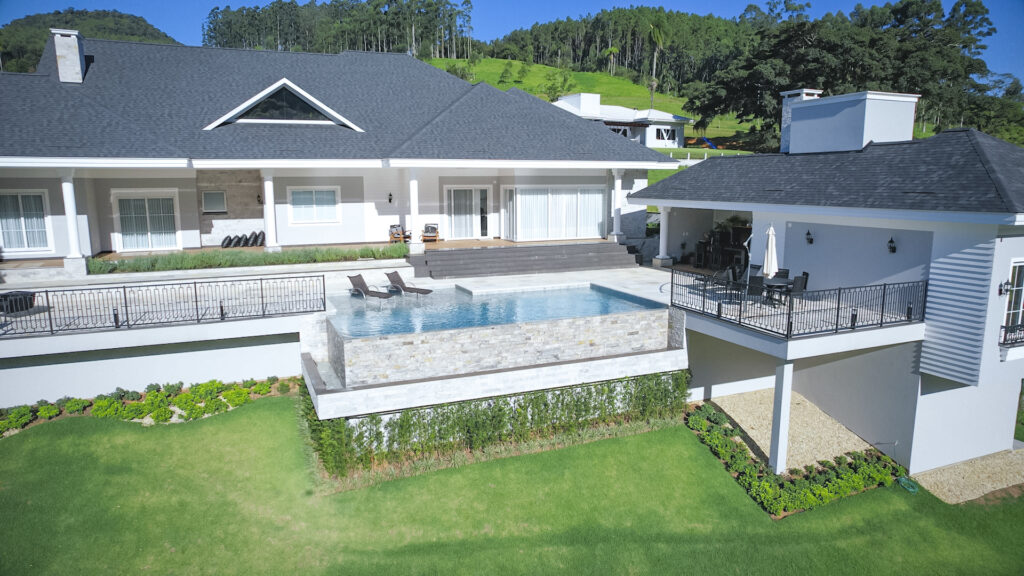 Vista aérea de residência com piscina projetada pela Ramiro Piscinas em Rio do Sul, Santa Catarina