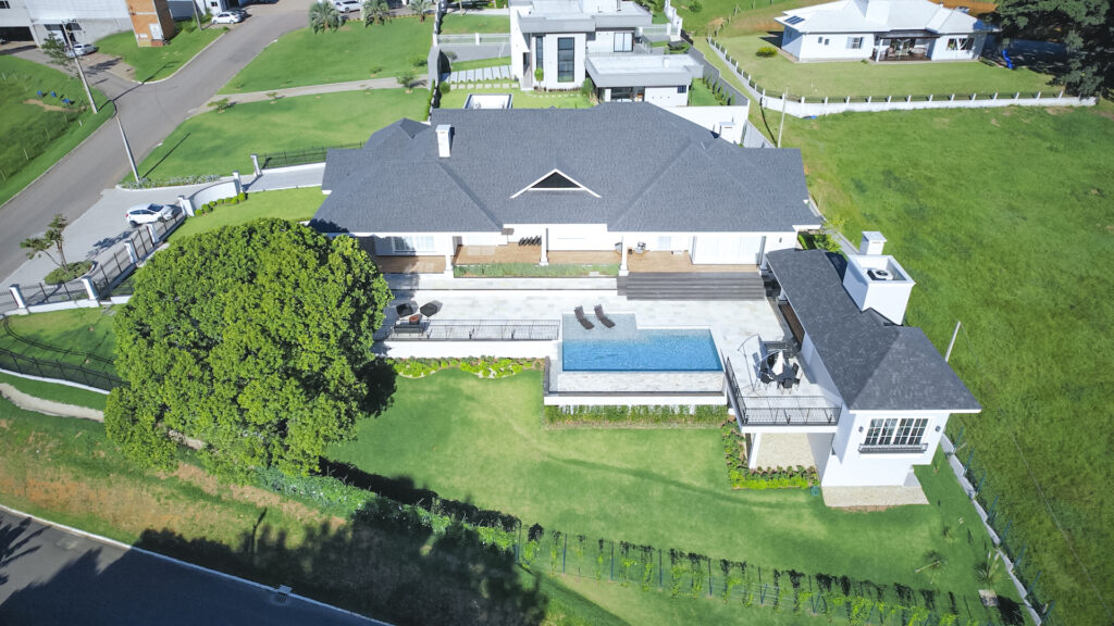 Vista aérea de residência com piscina integrada ao jardim e ao terraço